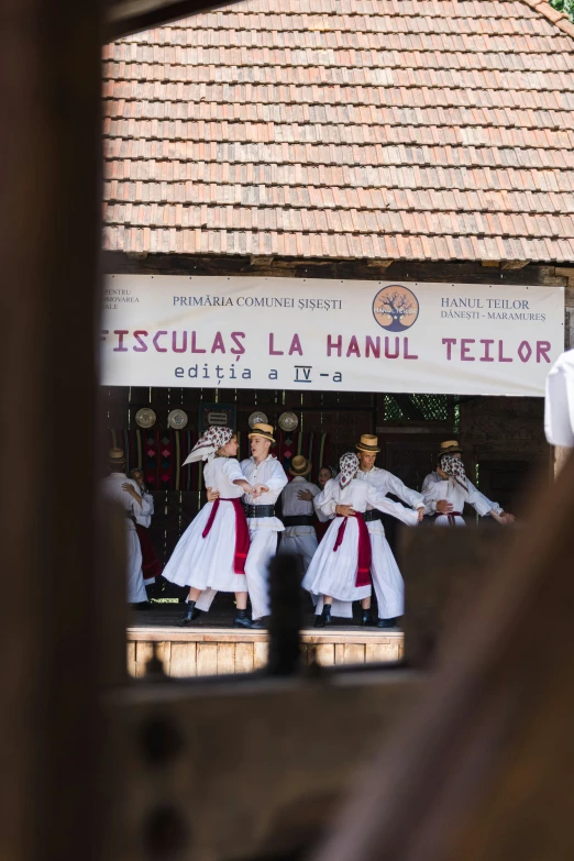 three women perform dances near a window on display