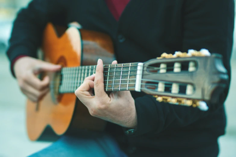 a man is playing the guitar while sitting on his knees