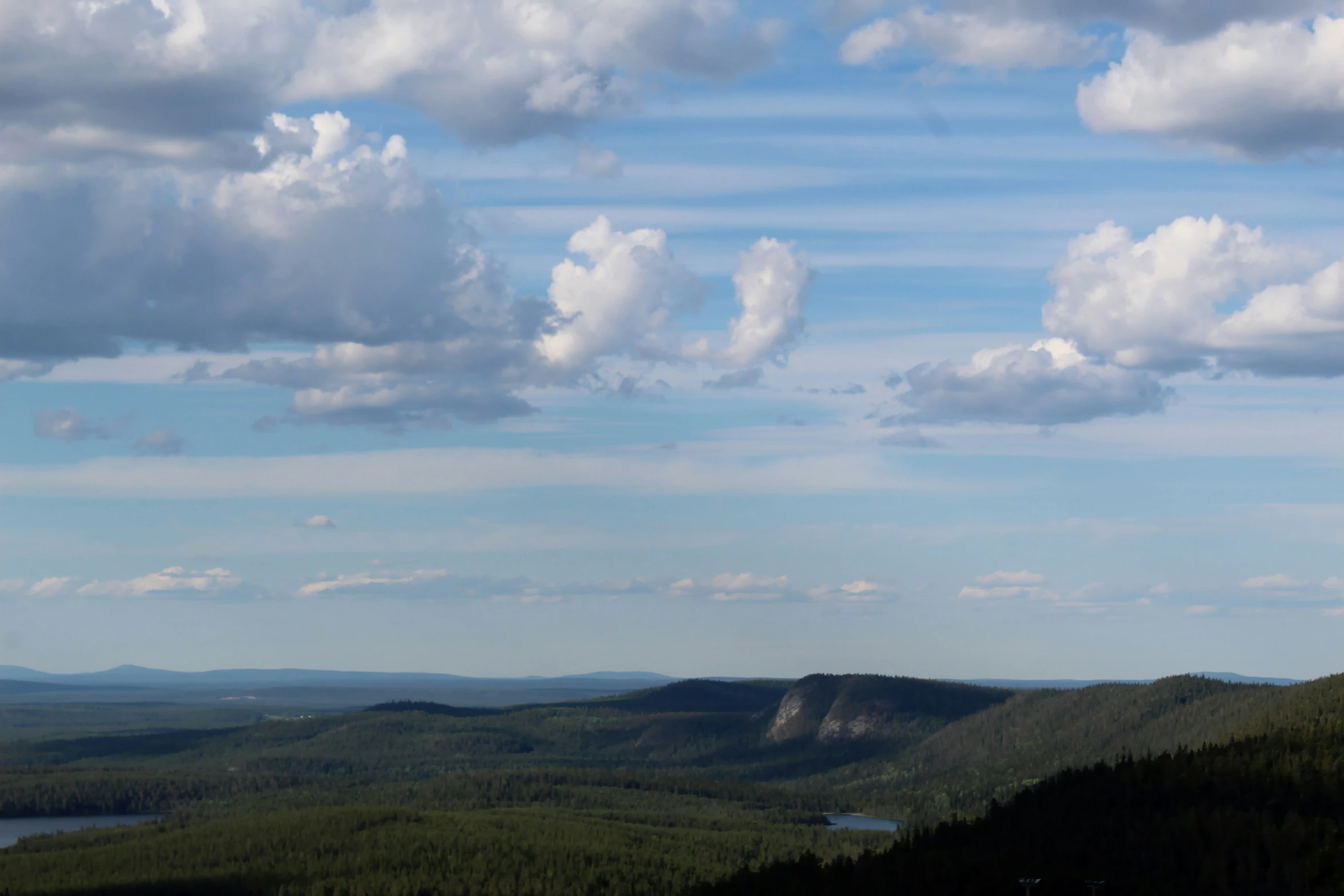 the clouds are getting pretty blue as they rise above a mountain