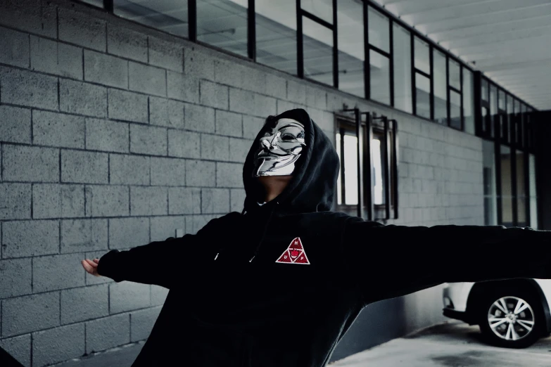 a man wearing a mask while standing outside of a building