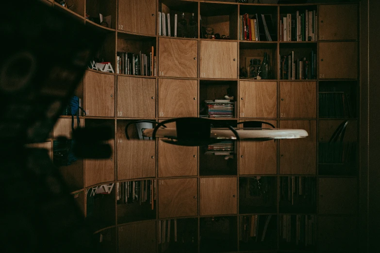 a wooden shelf is on the wall with many books