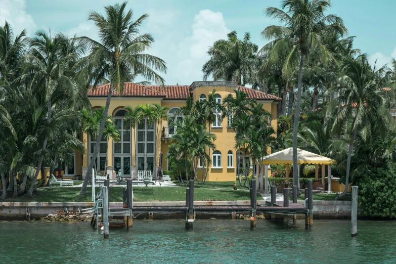 the view of a house near the water with some trees