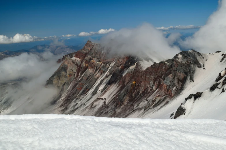 clouds rolling over the mountains with some skiers