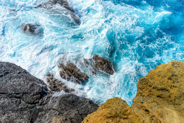 some rocks and water and one person is laying on it