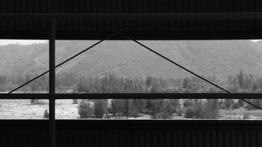a view of mountains, trees and a valley from inside a building