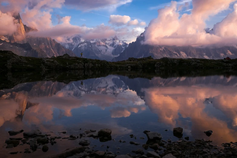 the mountains and water are covered with clouds