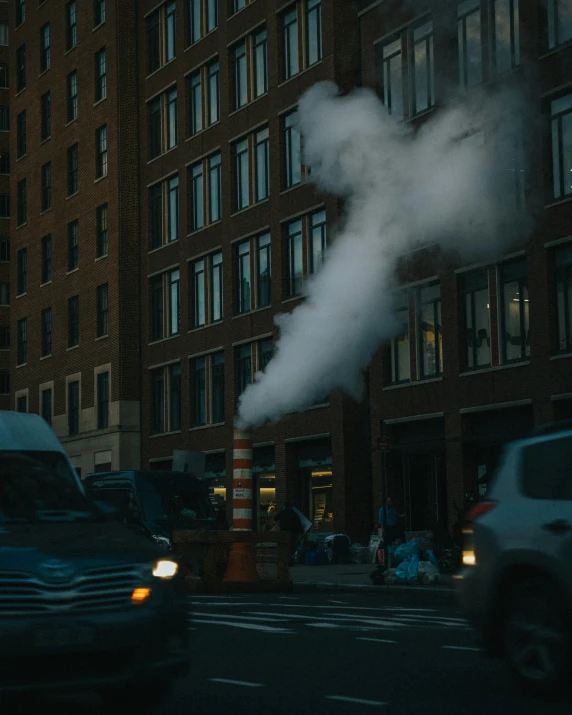 a smoke plumes from the side of a building into the air