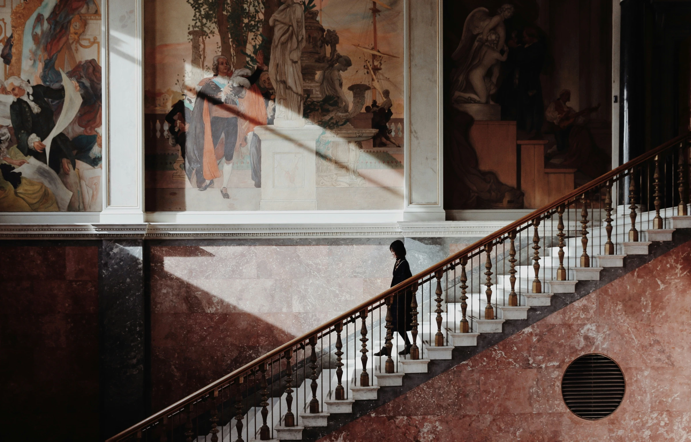 a woman walking down a large stairway way