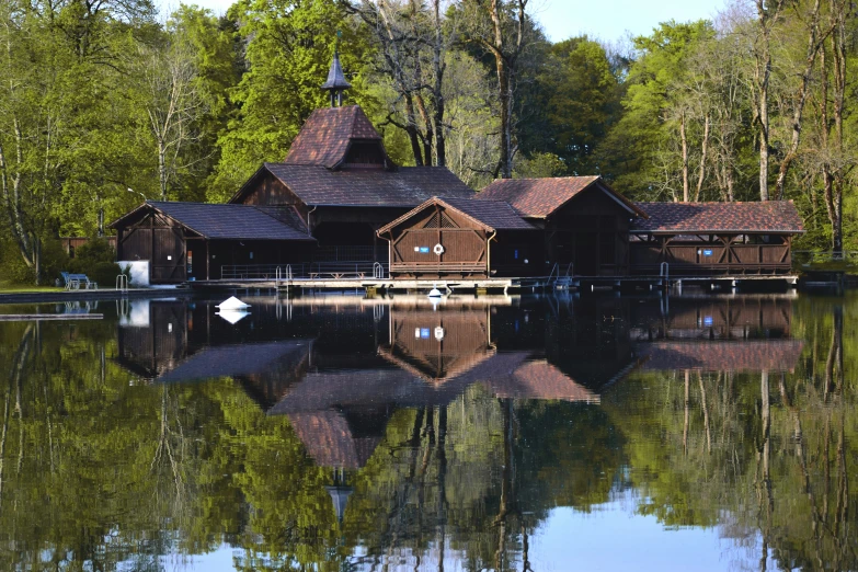 a lake with a house next to it surrounded by trees