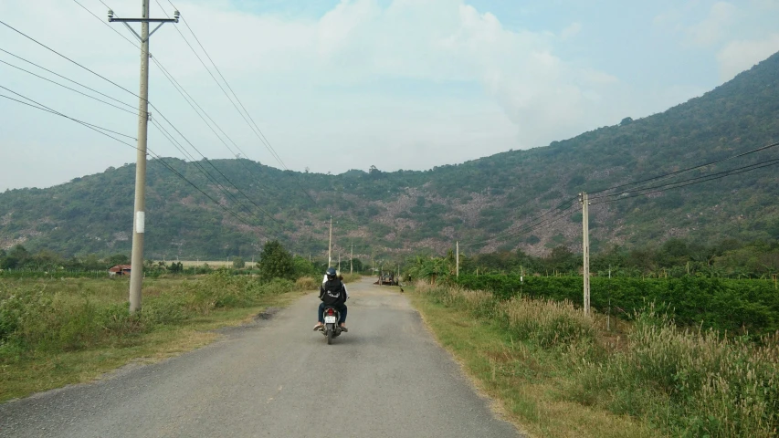 a person on a motorcycle riding down the road