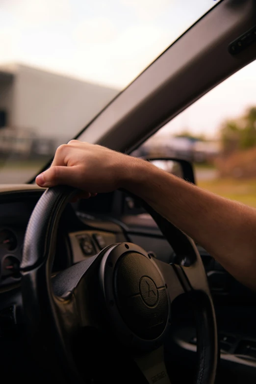 this is someone's hand on the steering wheel of a car