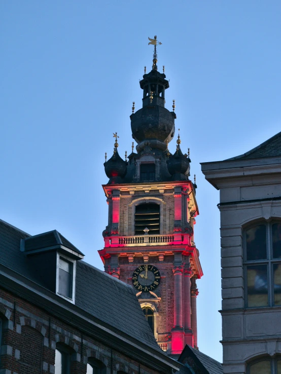 the clock is illuminated at the top of the tower