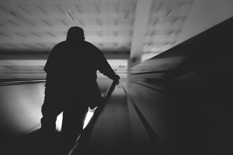 a man in a hooded coat is on a subway platform