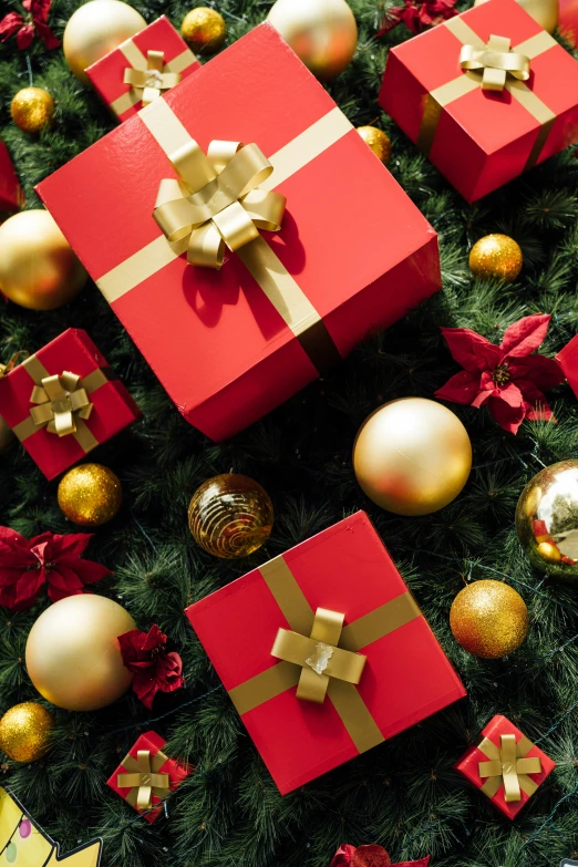 red and gold gift boxes surrounded by christmas ornaments