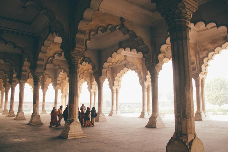 many people walk through a narrow corridor between arches