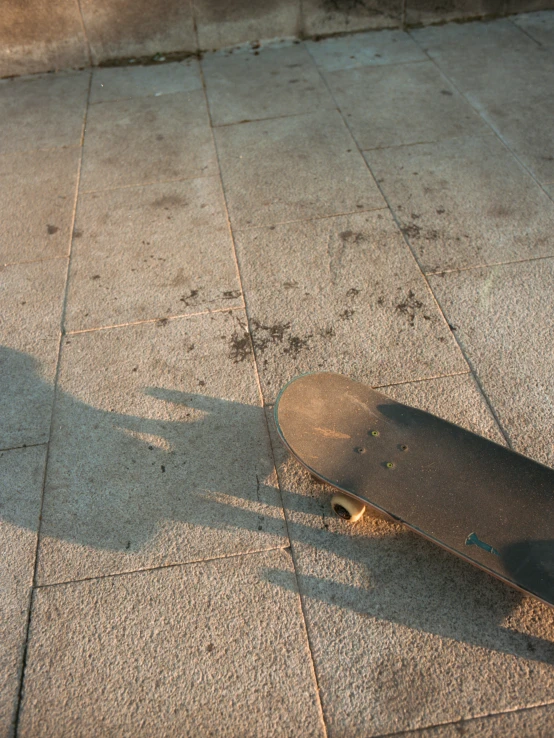 an upside down skateboard sitting on a sidewalk