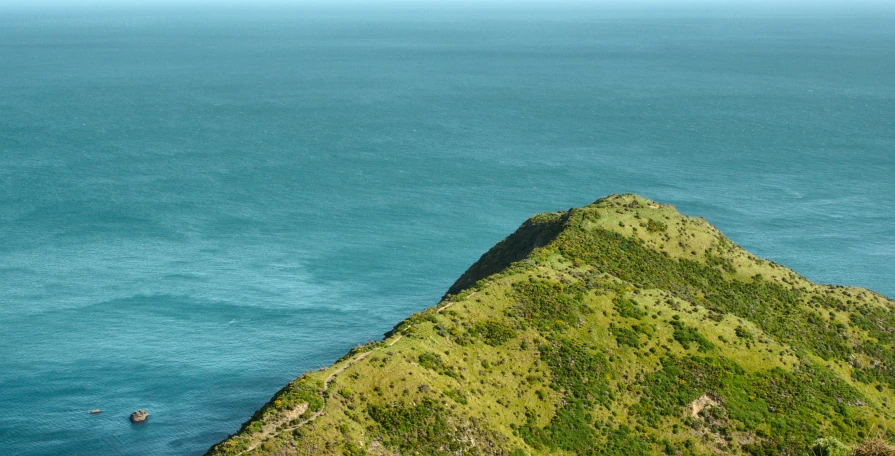 a boat is on the water off a hill