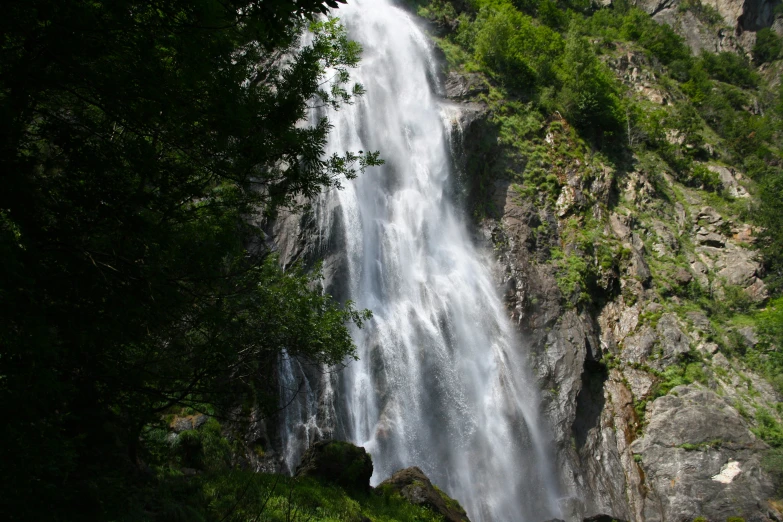 a group of people standing next to a waterfall