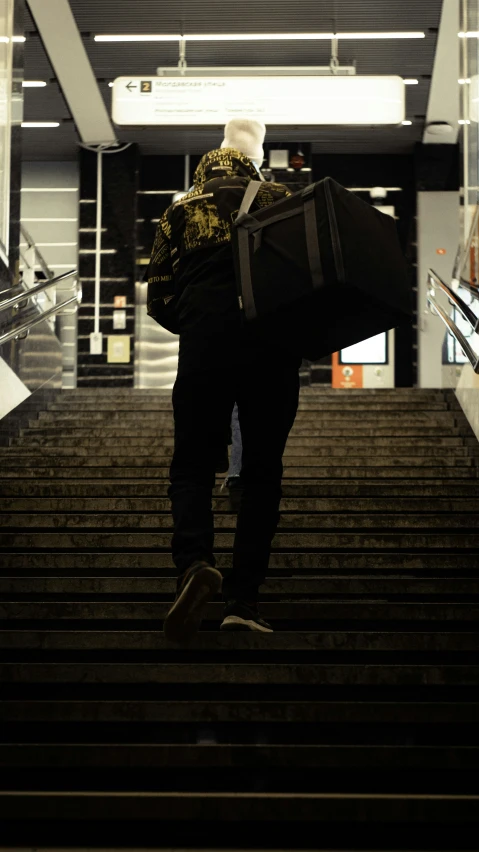 a man carrying a suit case up the stairs
