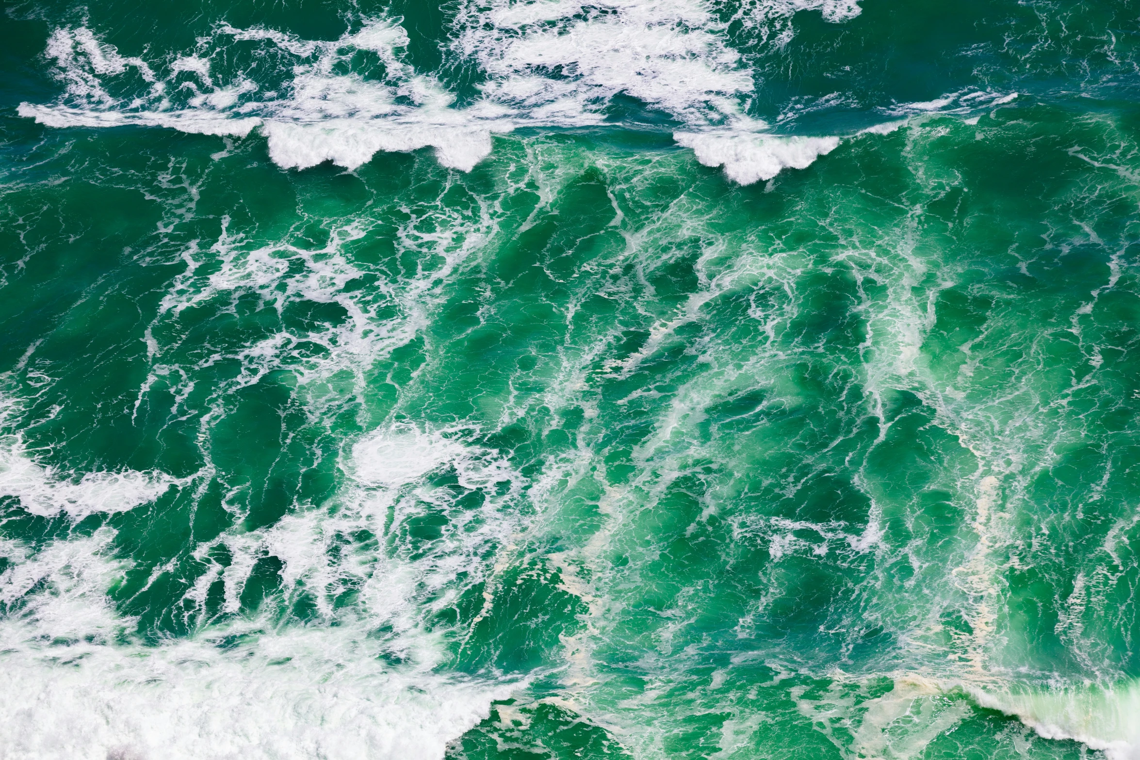 an aerial view of the ocean and surf