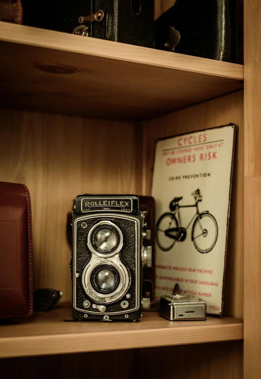 a vintage camera sitting on a shelf next to a book