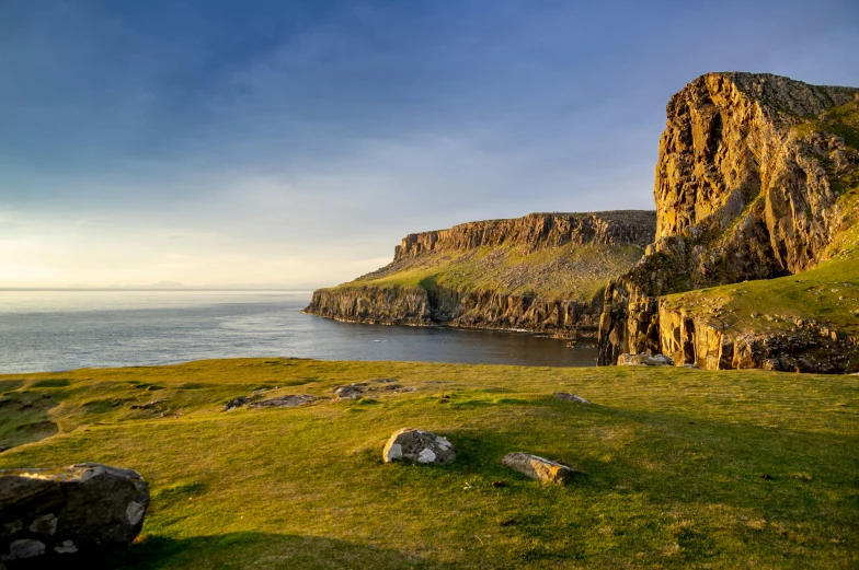 a rocky landscape is overlooking the water in the distance