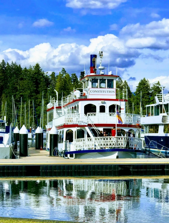 a white and red boat in the harbor by some water