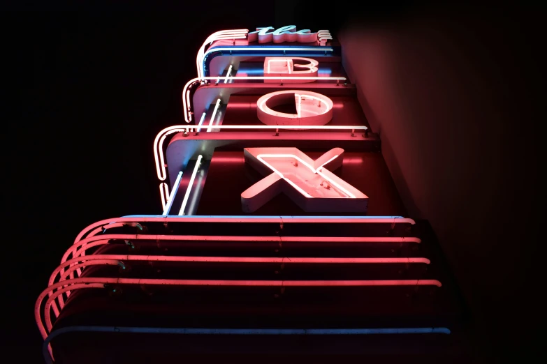 a tall neon sign with the letters xox on it