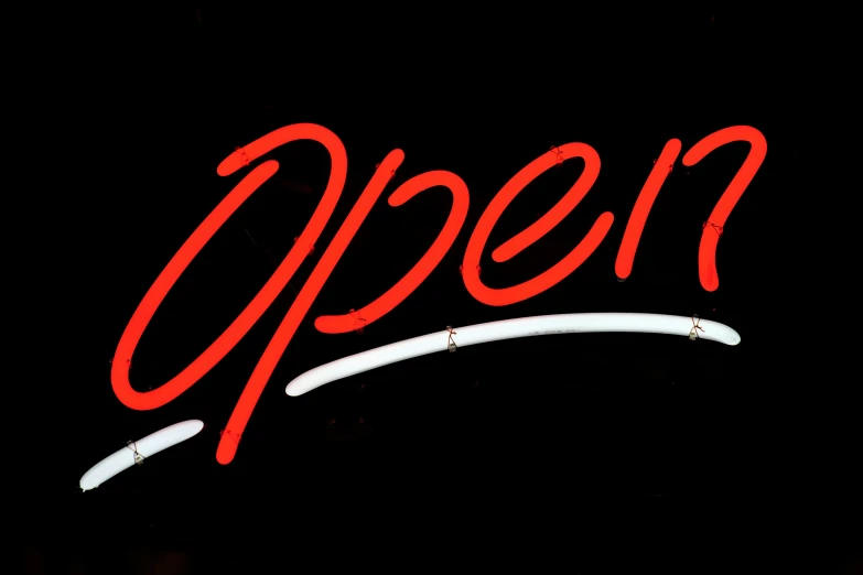a neon sign is shown in front of a dark background