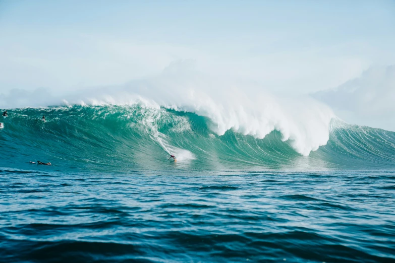 a group of people surfing on a wave in the ocean