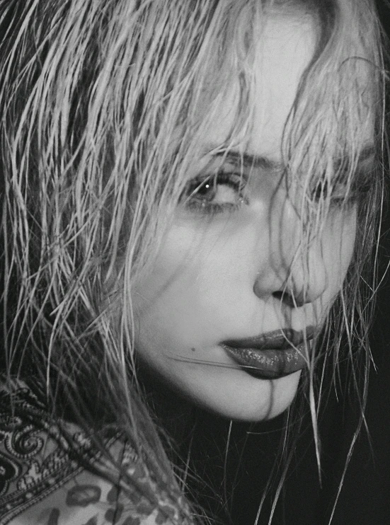 a woman with feathers on her hair is looking down at the ground