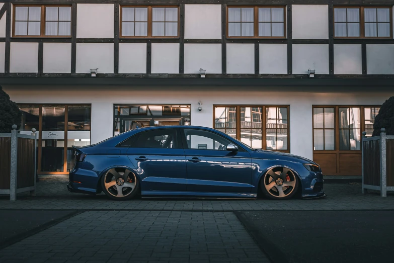 an extreme looking blue car parked in front of a building