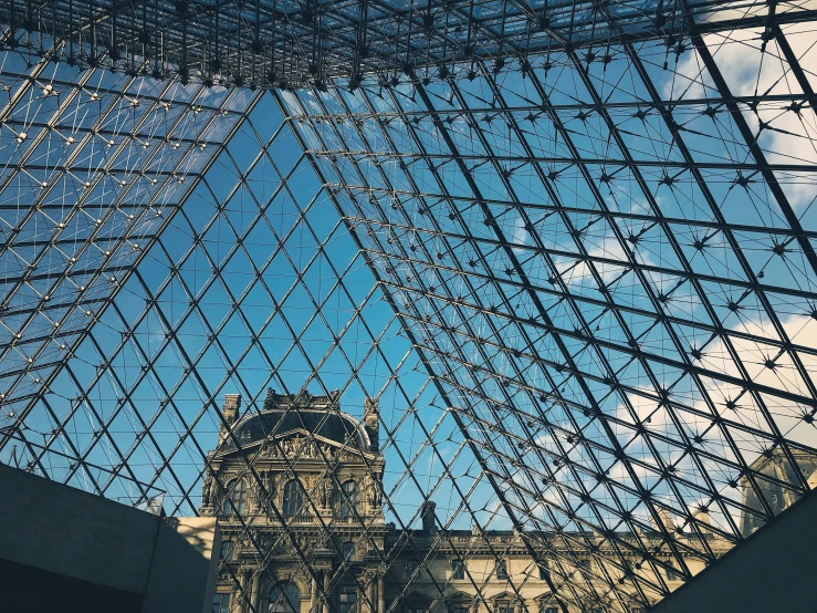 the view of a clock tower through an atrium