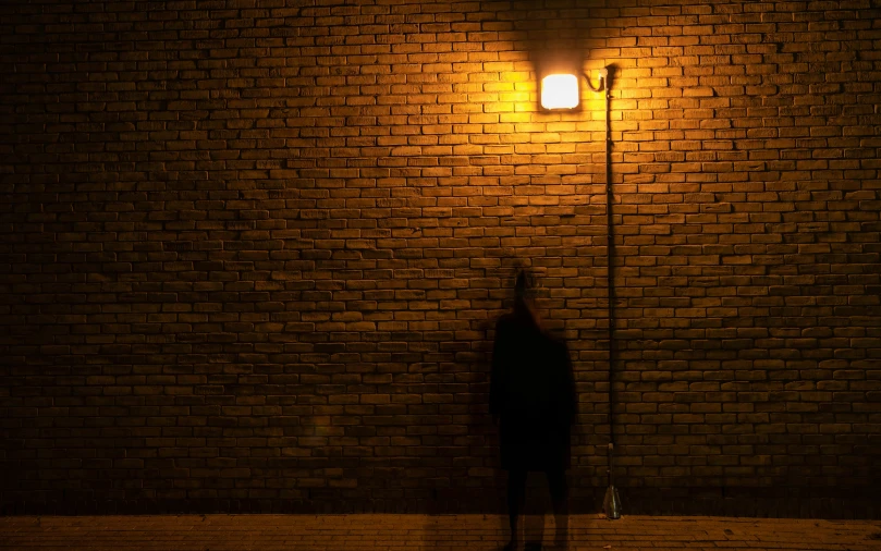 a man stands under an street light alone