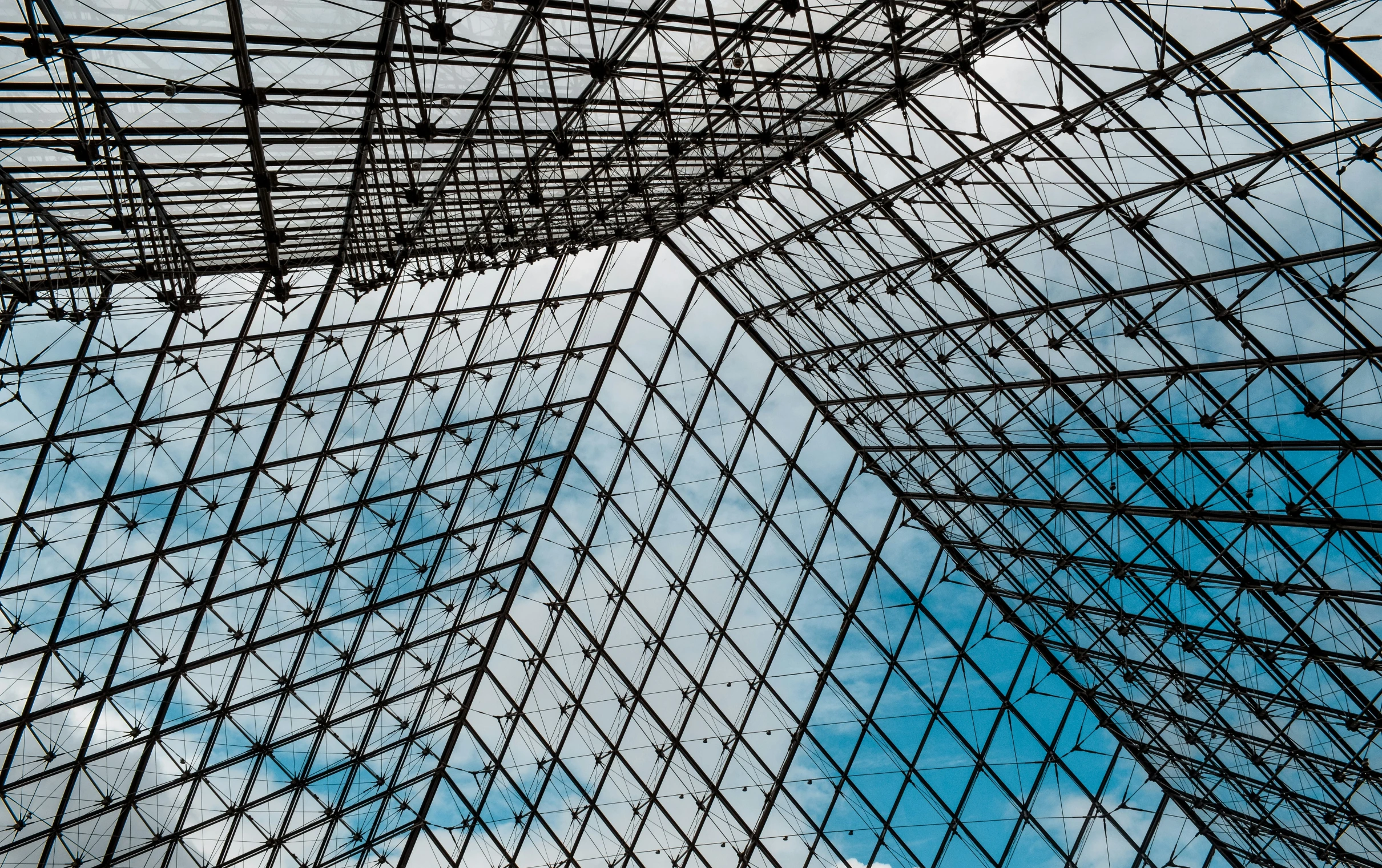 the top of an open structure looking up at a blue sky