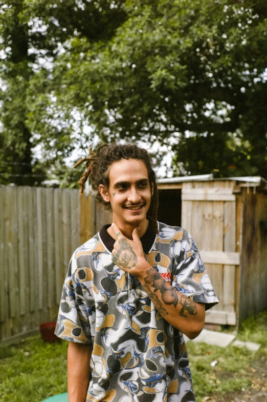 a man with dreadlocks standing outside in the grass