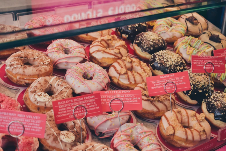 several different types of donuts displayed on shelves