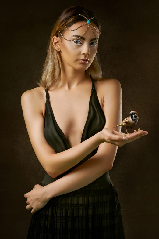 a woman holding an owl and a small bird