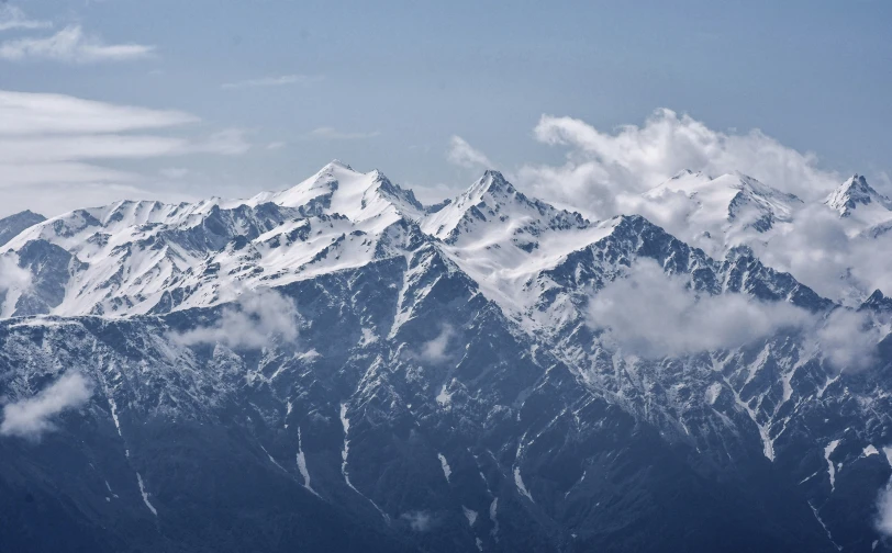 mountains with snow and clouds as seen from a plane