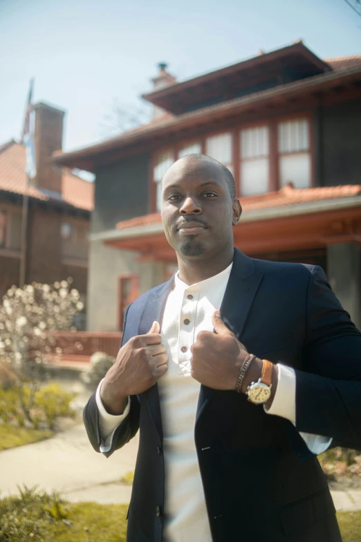 a man dressed in a suit standing outside a home