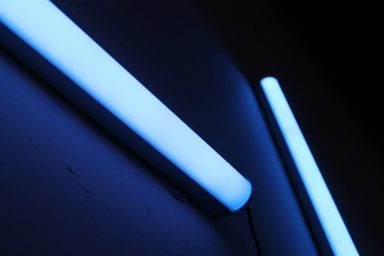 two blue and white lights glow from the bottom of a lit tube
