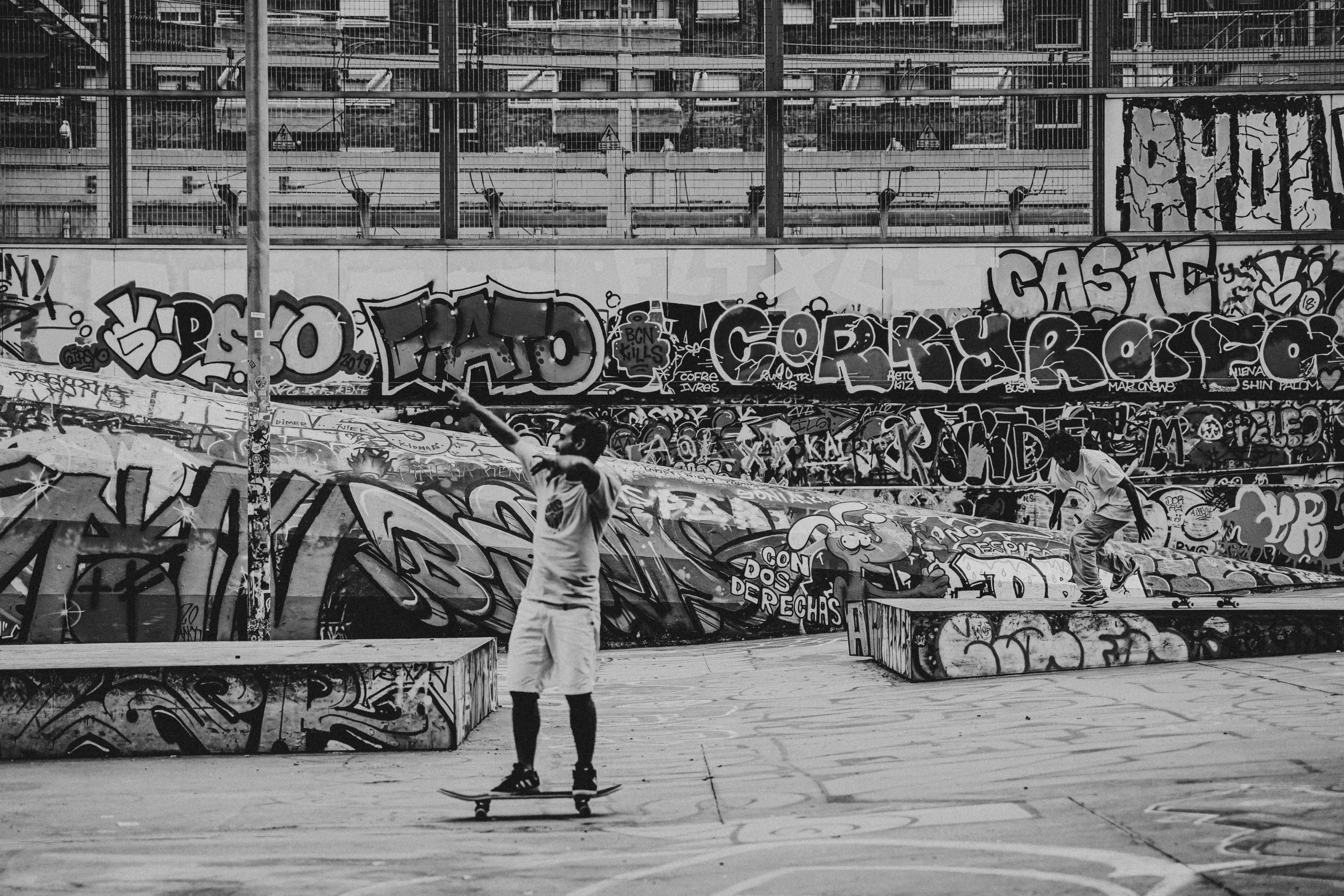 a person riding a skateboard past a wall covered in graffiti