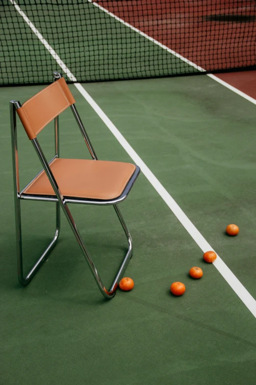 a chair sitting on top of a tennis court next to a net