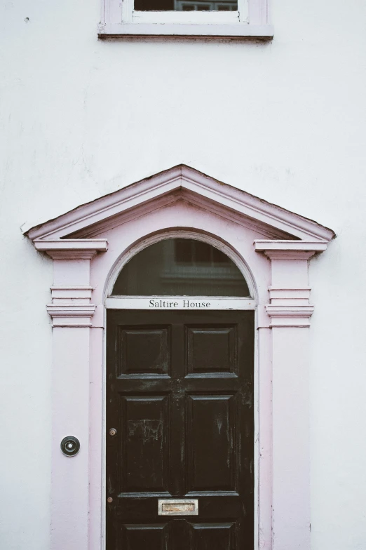 a black door sitting underneath a window under a window