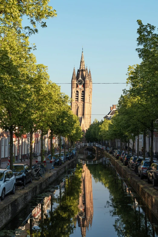 a view of a tall building on top of a hill next to the water