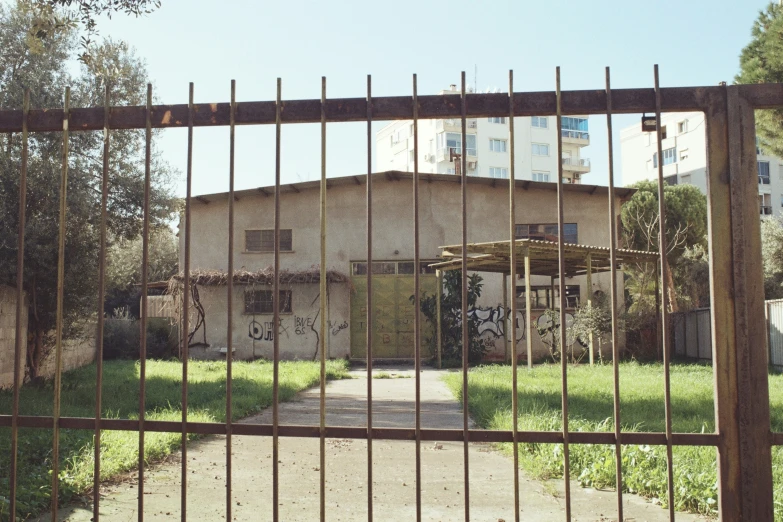 a house behind a metal fence with two bicycles parked outside it