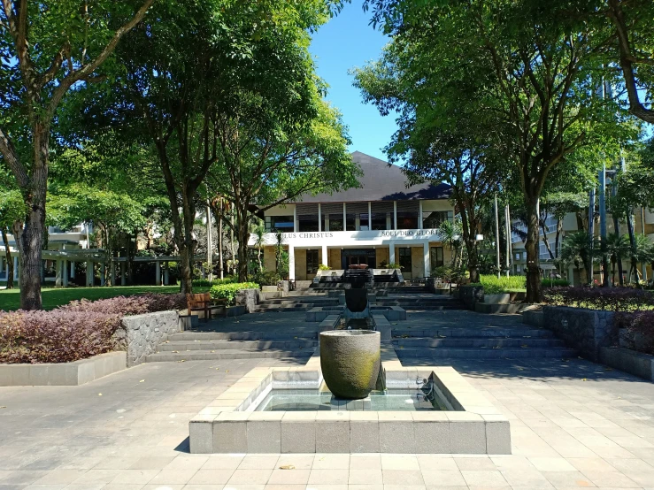 a fountain with two sculptures in front of a house