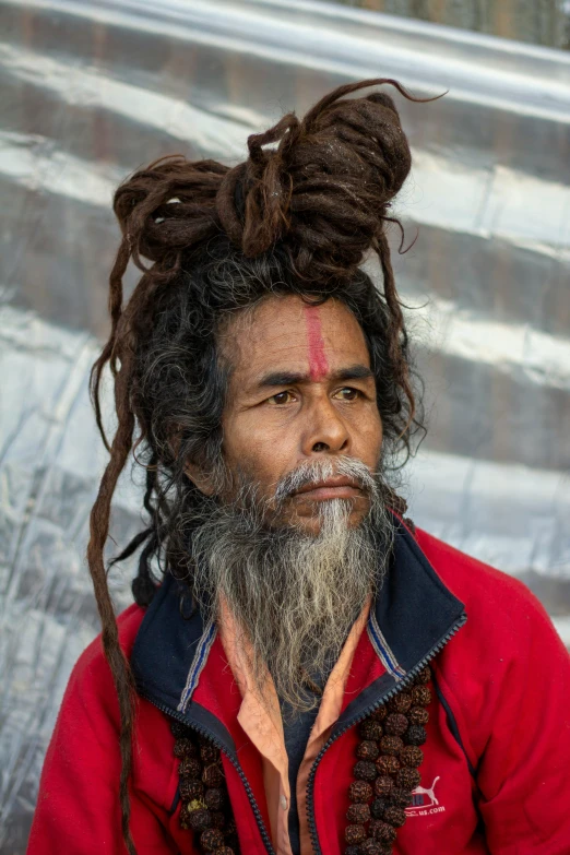 a man with dreadlocks, wearing a red shirt