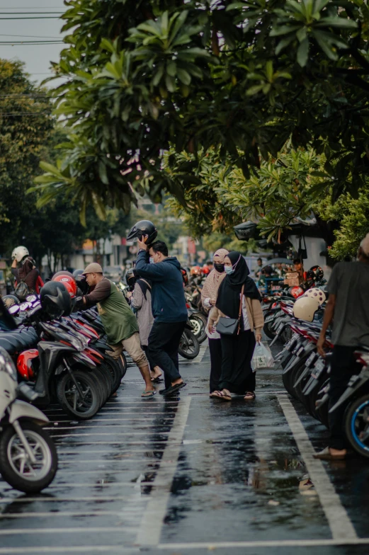 many people standing near a large row of motorcycles