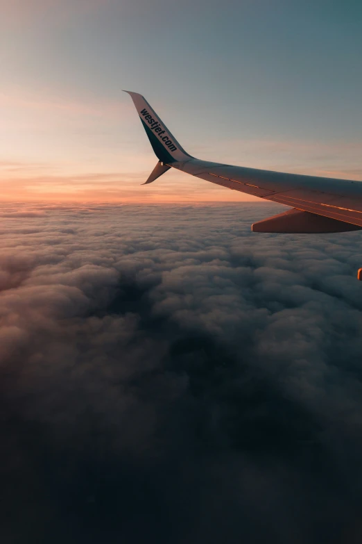 a jet flying in the sky with clouds